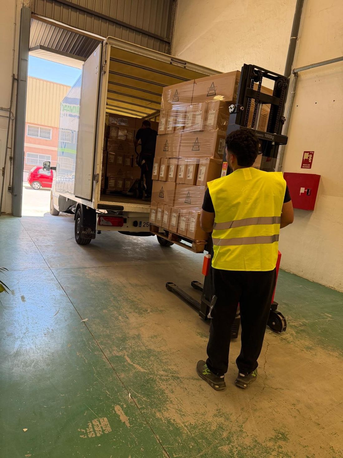 Equipo de Thrusterslogisticas descargando mercancía en el almacén de Valencia